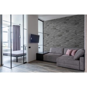 Szara ściana z cegły w salonie. Dekoracyjne kamienie i klinkier do wnętrz.