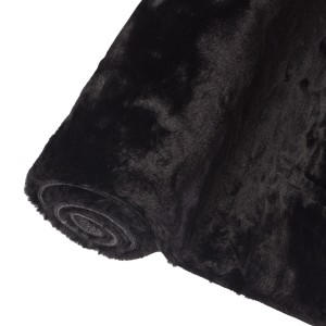 Zwinięty czarny dywan t.b.t. z długim włosiem.