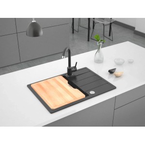Czarny zlewozmywak granitowy t.b.t. z baterią i drewnianą deską do krojenia na blacie kuchennym.