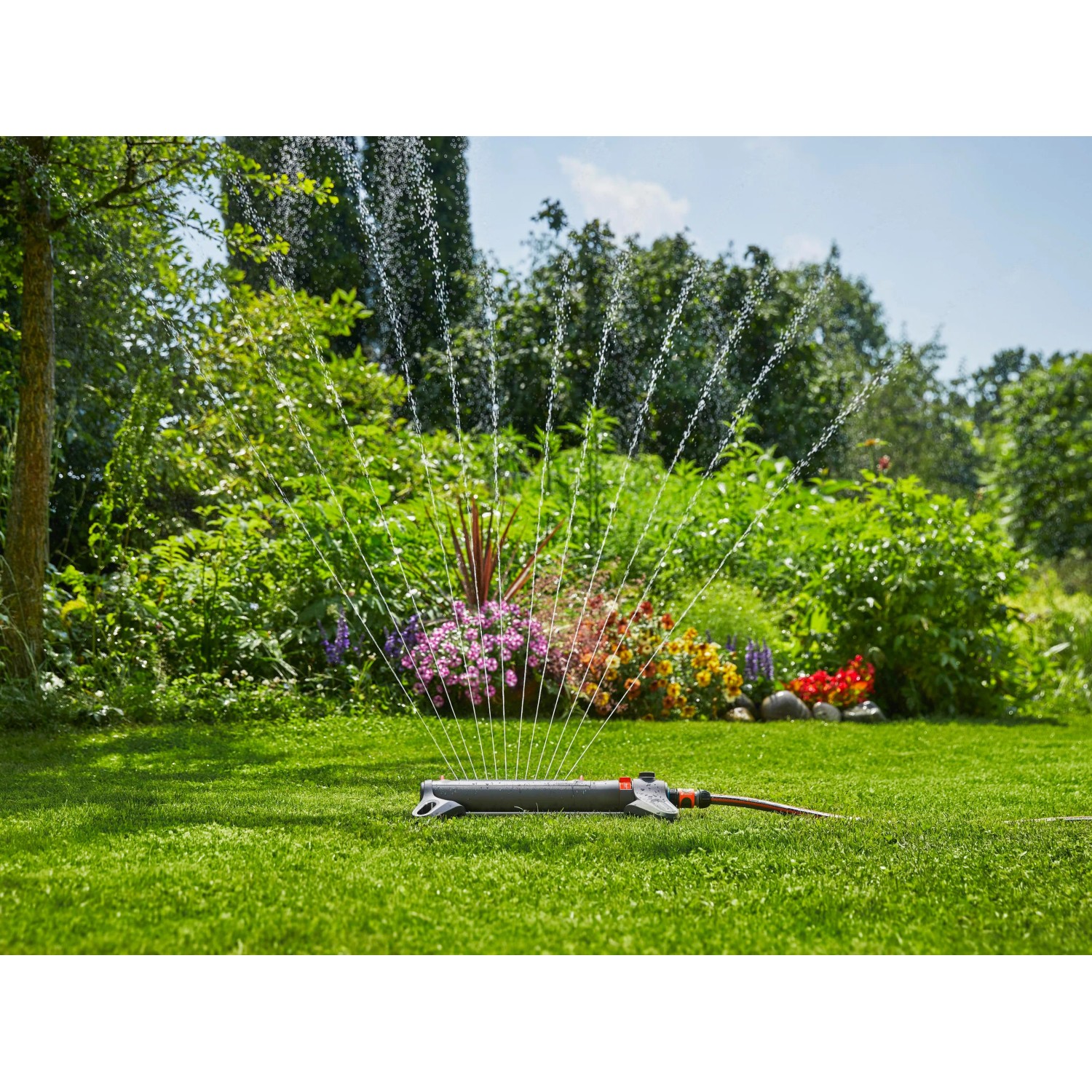 Zraszacz wahadłowy Gardena AquaZoom S nawadnia trawnik w ogrodzie.