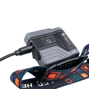 Zbliżenie ładowanej latarki czołowej t.b.t..