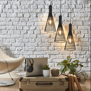 Trzy czarne lampy wiszące t.b.t. w nowoczesnym stylu na tle białej ściany z cegieł.