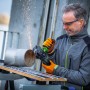 Mężczyzna szlifuje metalową rurę akumulatorową szlifierką kątową LUX A-WS-20/115. Lecą iskry.