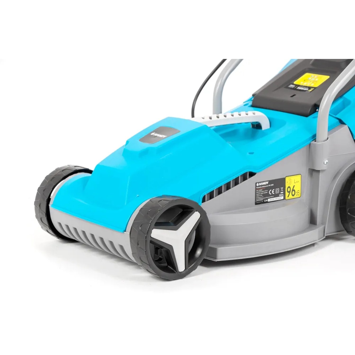 Zbliżenie na turkusową kosiarkę elektryczną. Ostrość na koła i obudowę.