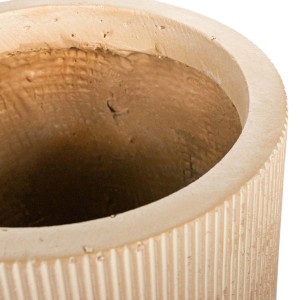 Zbliżenie okrągłej, beżowej doniczki t.b.t. z rowkowaną powierzchnią.