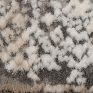 Zbliżenie: Dywan z długim włosiem t.b.t. we wzory w kolorze szarym i białym.
