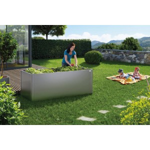 Ciemnoszara metalowa grządka Biohort z roślinami w ogrodzie, 77x102x102 cm.