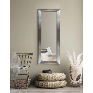 Prostokątne lustro do garderoby t.b.t. ze srebrną ramą na ścianie.