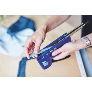 Zbliżenie: Osoba ładuje zszywki z cienkiego drutu do niebieskiego takera.