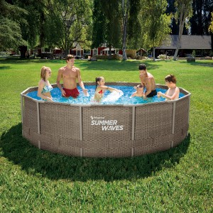 Rodzina w okrągłym basenie stelażowym t.b.t. Summer Waves w ogrodzie.