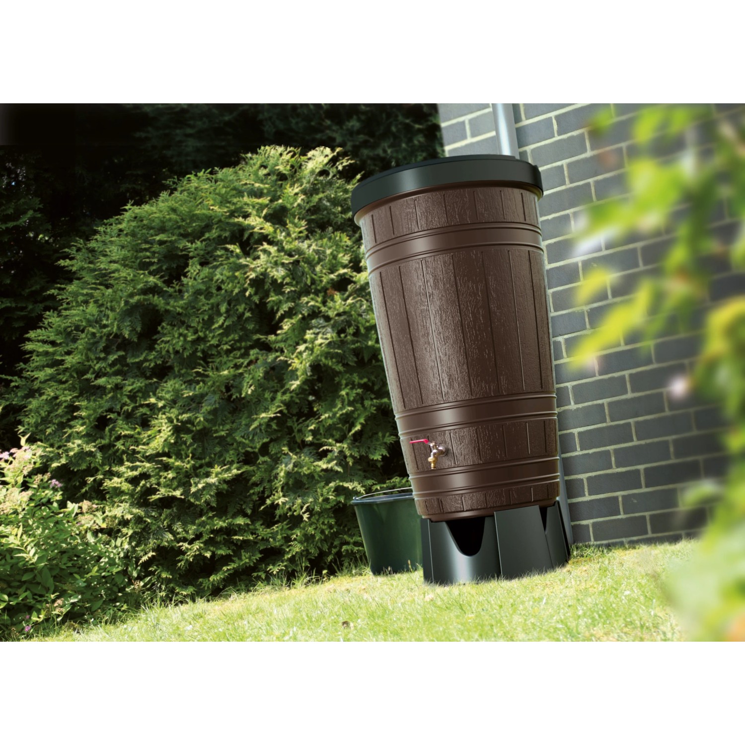 Brązowa beczka na deszczówkę Waterform Woodcan 265 l z kranem w ogrodzie.