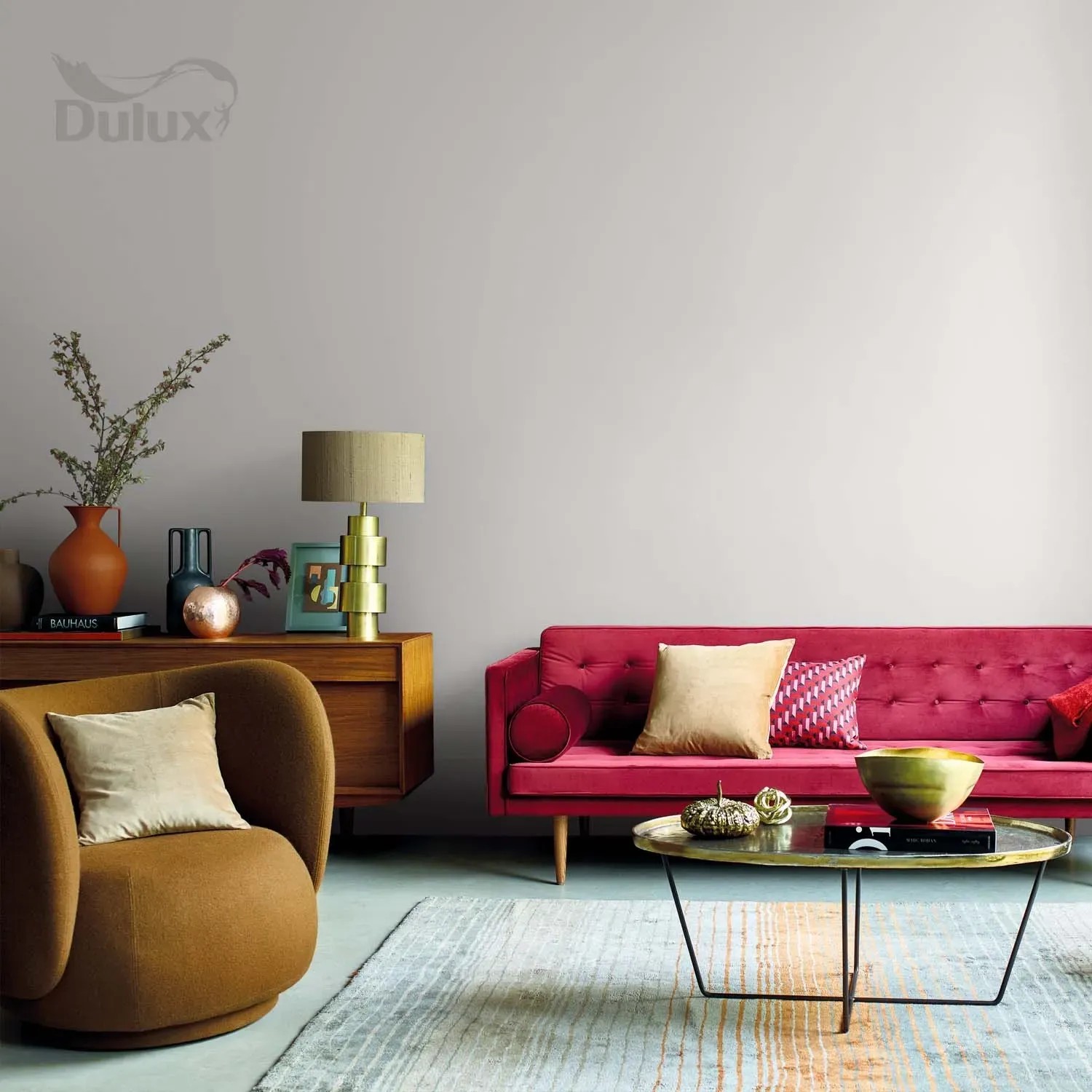 Pokój dzienny z farbą do ścian t.b.t. firmy Dulux, czerwona sofa, fotel i dywan.