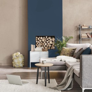 Salon z niebieską pomalowaną ścianą i drewnem opałowym. Kolorowa farba do ścian dla przytulnej atmosfery.