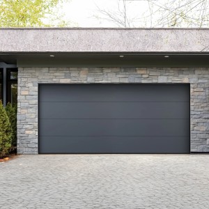 Nowoczesna szara brama garażowa z kamiennym murem. Brama garażowa do Twojego domu.