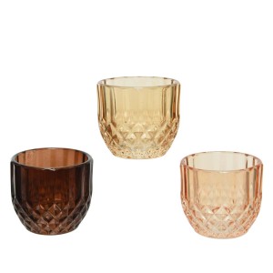 Trzy szklane świeczniki na tealighty w odcieniach brązu, żółci i różu z geometrycznym wzorem.