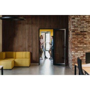 Pokój z panelami ściennymi t.b.t. o wyglądzie drewna, żółtą sofą i ceglaną ścianą.