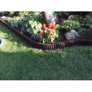 Brązowe obrzeże trawnikowe t.b.t. z tworzywa sztucznego w ogrodzie.