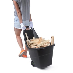 Czarny wózek ogrodowy Load and Go wypełniony drewnem, ciągnięty przez osobę.