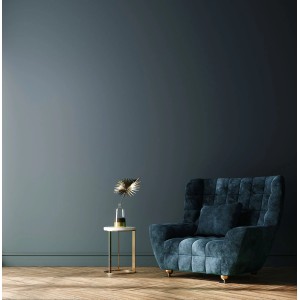 Salon z niebieską pomalowaną ścianą, fotelem i stolikiem bocznym. Kolorowa farba do ścian wewnętrznych.