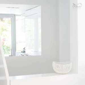 Jasny pokój z białą pomalowaną ścianą i dekoracyjną misą. Kolorowe farby do ścian.