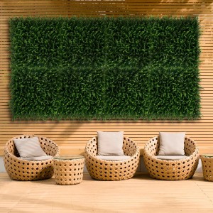 Zielona mata osłonowa t.b.t. jako element dekoracyjny na drewnianej ścianie w ogrodzie.