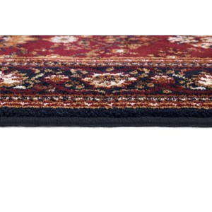 Zbliżenie czerwonego dywanu z krótkim włosiem i orientalnym wzorem.