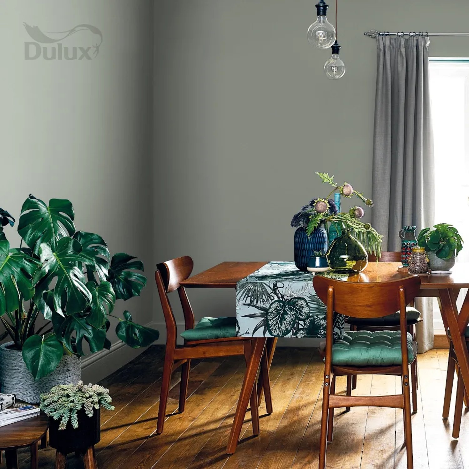 Pokój dzienny z farbą ścienną Dulux w stonowanej zieleni. Kolorowe farby ścienne dla przytulnej atmosfery.