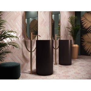 Łazienka z różowymi płytkami ściennymi t.b.t. ułożonymi w jodełkę i czarnymi umywalkami.