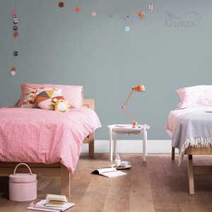 Pokój dziecięcy z dwoma łóżkami i pastelową niebieską farbą na ścianach. Kolorowe farby do ścian dla przyjaznej atmosfery.