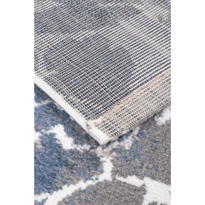 Zbliżenie dywanu z krótkim włosiem w niebiesko-szary wzór z białymi akcentami.