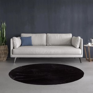 Czarny, okrągły dywan z długim włosiem przed sofą. Przytulny akcent do salonu.