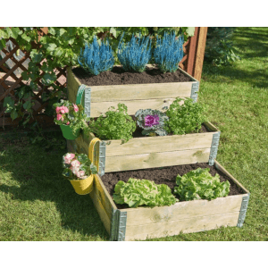 Wielopoziomowa drewniana grządka podwyższona z roślinami w ogrodzie.