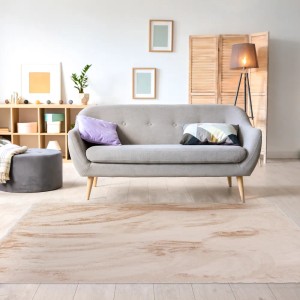 Beżowy dywan z długim włosiem w salonie z sofą i dekoracjami.