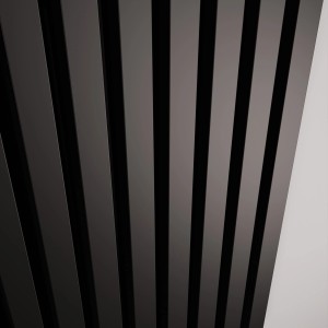 Zbliżenie grzejnika t.b.t. z czarnymi lamelami.