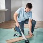 Mężczyzna tnie laminat za pomocą obcinaka do laminatu wolfcraft LC 600. Narzędzie do precyzyjnego cięcia laminatu.
