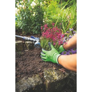 Zielone rękawice robocze t.b.t. podczas sadzenia rośliny w ogrodzie.