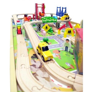 Zbliżenie na świat zabaw t.b.t. z drewnianą kolejką, samochodami i znakami drogowymi dla dzieci.