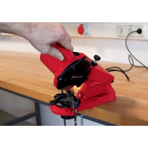 Ostrzałka do łańcuchów Einhell GC-CS 85 E w kolorze czerwonym podczas ostrzenia łańcucha.