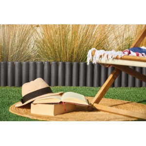 Szare obrzeże rabaty t.b.t. w ogrodzie z książką i kapeluszem na dywanie.