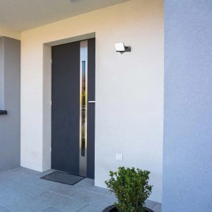 Zewnętrzny reflektor LED na ścianie domu obok drzwi. Wodoodporne oświetlenie do użytku na zewnątrz.