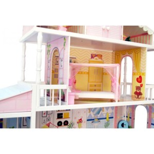 Zbliżenie wielopiętrowego, różowo-białego domku dla lalek t.b.t. z meblami.