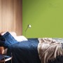 Sypialnia z zieloną farbą na ścianie. Kolorowa farba do ścian wewnętrznych firmy t.b.t.
