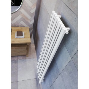 Biały grzejnik t.b.t. na szarej ścianie w łazience.