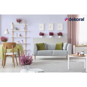 Salon w kolorze liliowym z dekoracją i szarą kanapą, pomalowany farbą do ścian t.b.t.