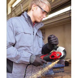 Mężczyzna szlifuje metal czerwoną szlifierką kątową Einhell TE-AG 125 CE, iskry lecą.