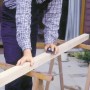 Rzemieślnik szlifuje drewno za pomocą klocka ściernego LUX 70x130 mm dla precyzyjnych rezultatów.