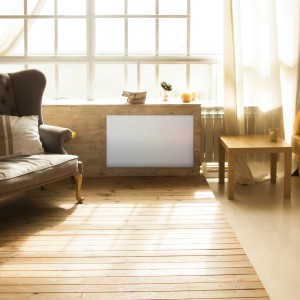 Grzejnik elektryczny t.b.t. w salonie z fotelem i stołem.