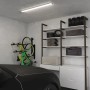 Lampa warsztatowa t.b.t. na suficie garażu, półki z oponami i rowery w tle.