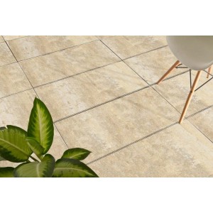 Beżowe płyty tarasowe t.b.t. z rośliną i krzesłem na tarasie.