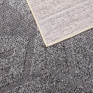 Zbliżenie szarego dywanu z długim włosiem t.b.t. z antypoślizgowym spodem.